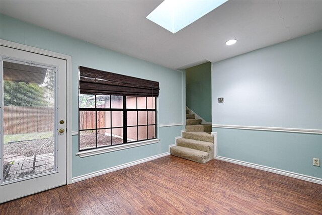 614 Brookfield Dr, Garland, TX 75040 - unfurnished room featuring a skylight, wood finished floors, stairway, baseboards, and recessed lighting