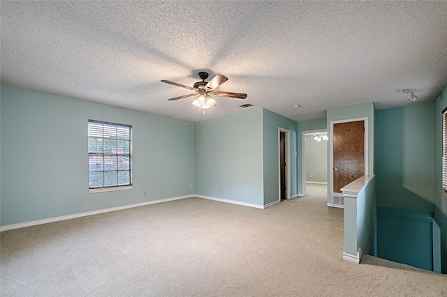 614 Brookfield Dr, Garland, TX 75040 - spare room with light colored carpet, a ceiling fan, baseboards, and a textured ceiling