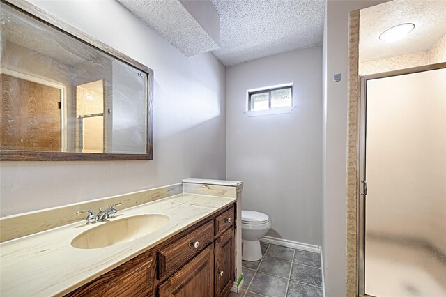 614 Brookfield Dr, Garland, TX 75040 - full bath featuring vanity, a stall shower, toilet, a textured ceiling, and tile patterned flooring