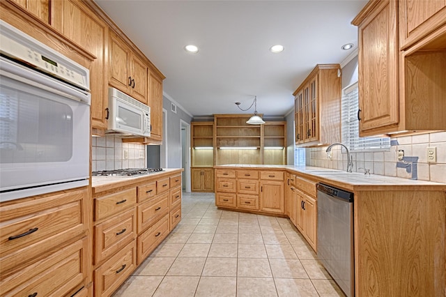 614 Brookfield Dr, Garland, TX 75040 - kitchen featuring appliances with stainless steel finishes, a sink, decorative backsplash, light countertops, and light tile patterned floors