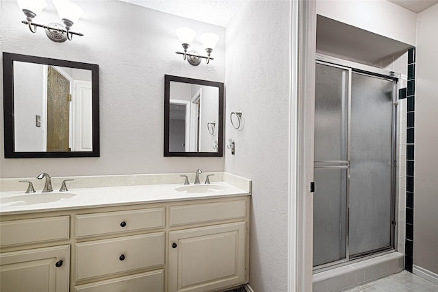 614 Brookfield Dr, Garland, TX 75040 - bathroom featuring a stall shower, double vanity, and a textured wall