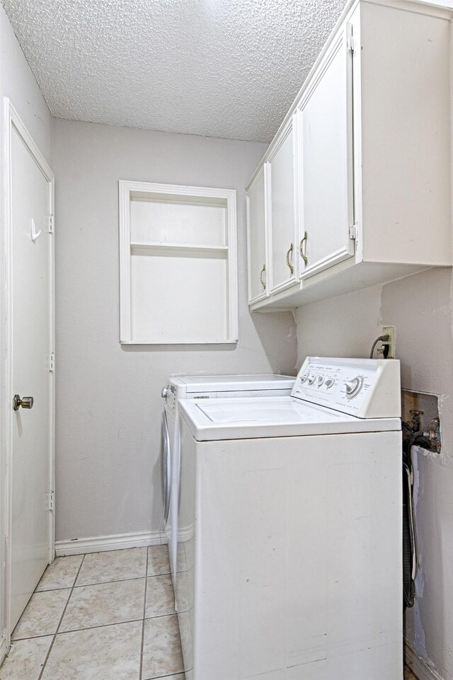 614 Brookfield Dr, Garland, TX 75040 - laundry room with washer and dryer, cabinet space, a textured ceiling, light tile patterned floors, and baseboards