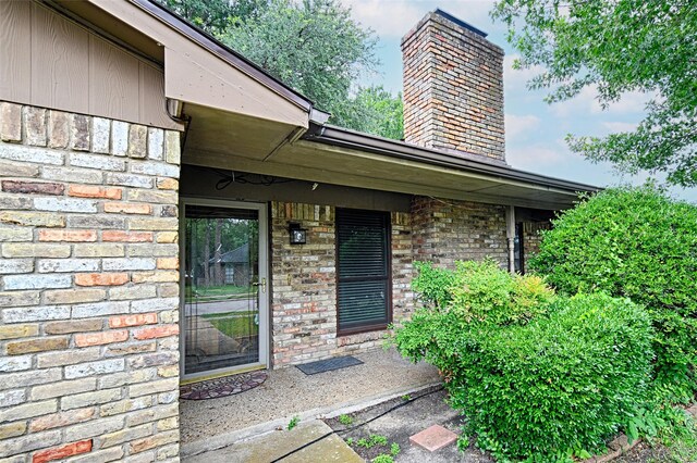 614 Brookfield Dr, Garland, TX 75040 - view of exterior entry with a chimney and brick siding