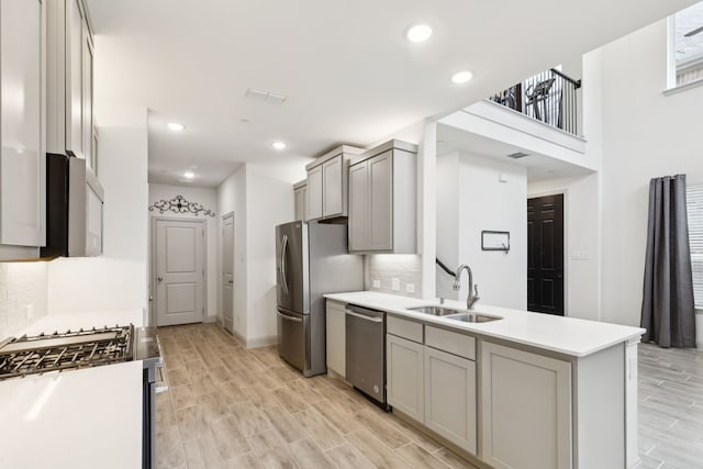 984 Mikaela Dr, Allen, TX 75013 - kitchen featuring appliances with stainless steel finishes, a sink, gray cabinets, light wood finished floors, and recessed lighting