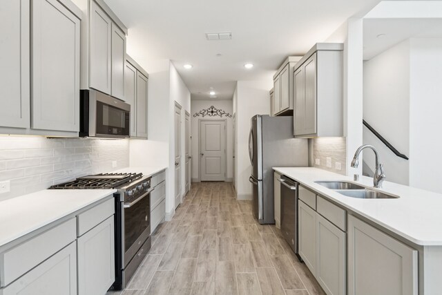 984 Mikaela Dr, Allen, TX 75013 - kitchen with stainless steel appliances, a sink, gray cabinets, tasteful backsplash, and recessed lighting