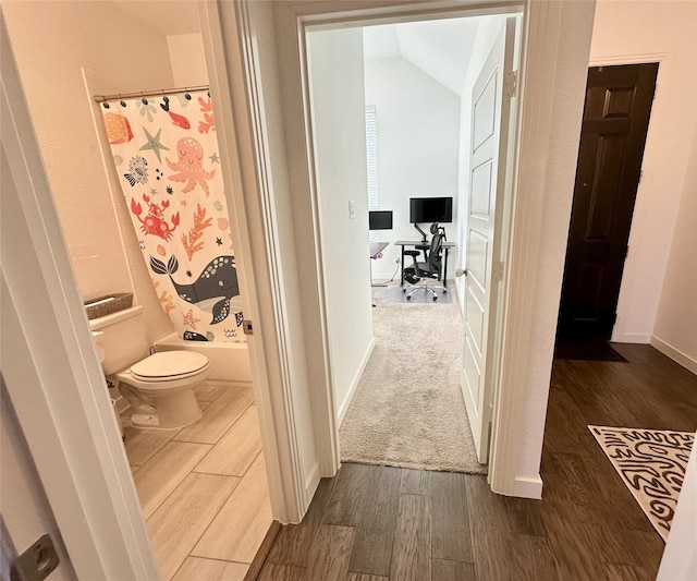 10029 Denali Dr, Little Elm, TX 75068 - corridor with dark wood-style floors, a desk, vaulted ceiling, and baseboards