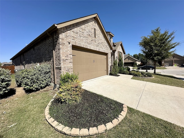 10029 Denali Dr, Little Elm, TX 75068 - view of side of property featuring brick siding, an attached garage, and driveway