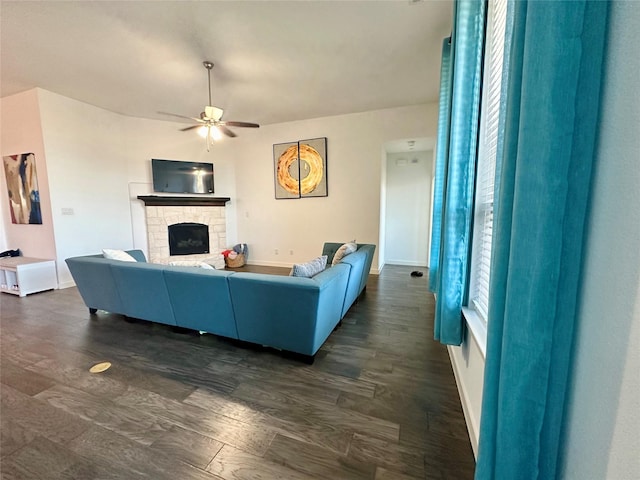 10029 Denali Dr, Little Elm, TX 75068 - living area featuring a ceiling fan, baseboards, a fireplace, and dark wood-style flooring