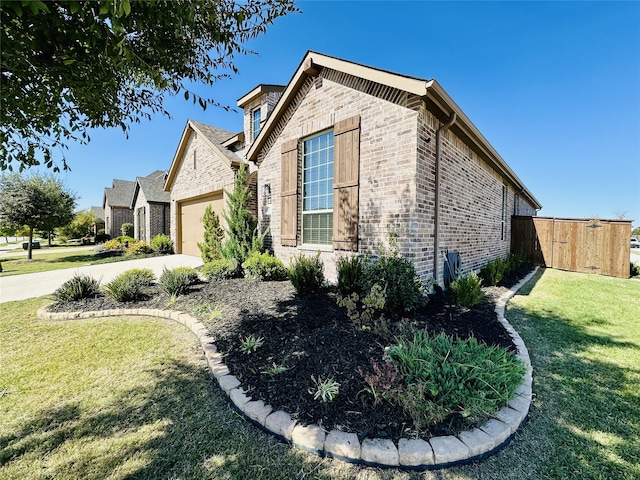 10029 Denali Dr, Little Elm, TX 75068 - view of side of home featuring brick siding, an attached garage, a lawn, and driveway