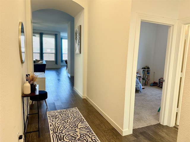 10029 Denali Dr, Little Elm, TX 75068 - hallway featuring dark wood-type flooring, arched walkways, and baseboards