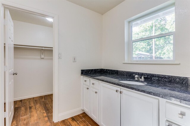 4704 S Drive, Fort Worth, TX 76109 - bathroom with wood finished floors, vanity, baseboards, and a walk in closet