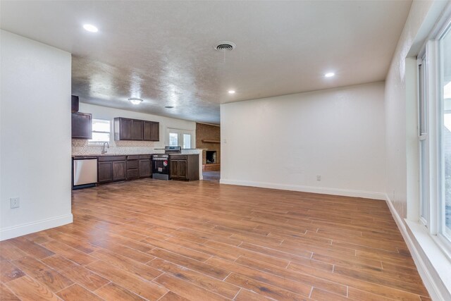 4704 S Drive, Fort Worth, TX 76109 - unfurnished living room featuring light wood finished floors, recessed lighting, baseboards, and a sink