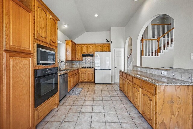 315 Hudson Falls Dr, Arlington, TX 76002 - kitchen with stainless steel appliances, a sink, light stone counters, tasteful backsplash, and arched walkways