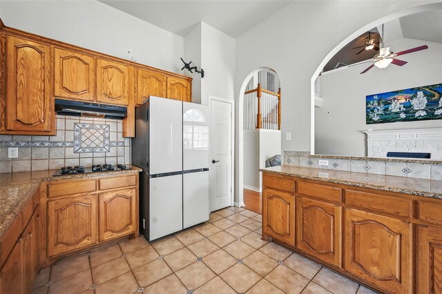 315 Hudson Falls Dr, Arlington, TX 76002 - kitchen with freestanding refrigerator, ceiling fan, decorative backsplash, arched walkways, and lofted ceiling