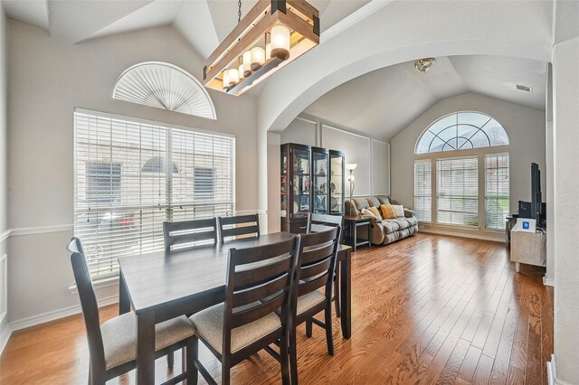 315 Hudson Falls Dr, Arlington, TX 76002 - dining space with arched walkways, vaulted ceiling, light wood finished floors, and baseboards