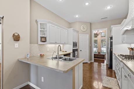 240 Lakeside Oaks Cir, Lakeside, TX 76135 - kitchen featuring a sink, appliances with stainless steel finishes, light countertops, backsplash, and white cabinets
