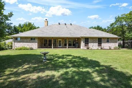 240 Lakeside Oaks Cir, Lakeside, TX 76135 - rear view of house with a yard, a chimney, and stone siding