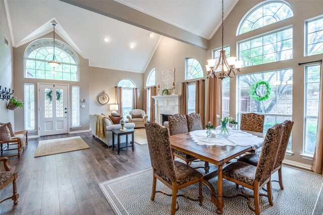 5909 La Cumbre Dr, Mckinney, TX 75072 - dining area featuring high vaulted ceiling, healthy amount of natural light, a chandelier, dark wood-type flooring, and a fireplace