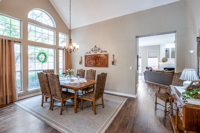 5909 La Cumbre Dr, Mckinney, TX 75072 - dining space with healthy amount of natural light, dark wood-style flooring, high vaulted ceiling, a chandelier, and ornamental molding