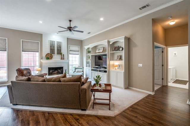 5909 La Cumbre Dr, Mckinney, TX 75072 - living area featuring wood finished floors, ceiling fan, a fireplace, crown molding, and baseboards