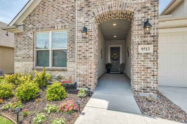 9513 Windwood Ln, Denton, TX 76207 - view of exterior entry featuring a garage and brick siding