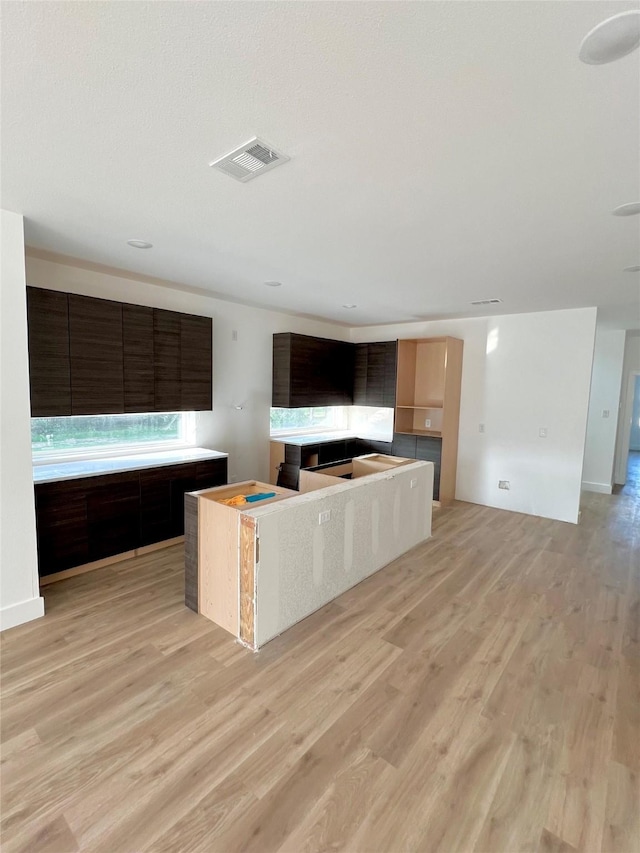 3514 Wendelkin St, Dallas, TX 75215 - kitchen featuring light wood-type flooring, a center island, modern cabinets, and open floor plan