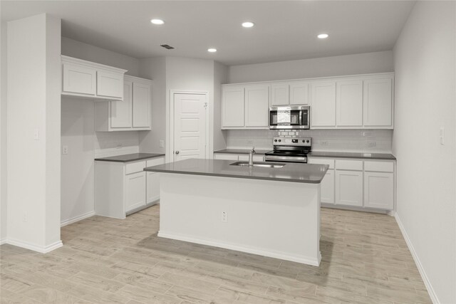 2006 Iris, Melissa, TX 75454 - kitchen with appliances with stainless steel finishes, a sink, dark countertops, decorative backsplash, and an island with sink