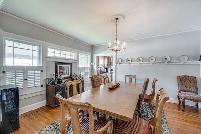2220 Mistletoe Blvd, Fort Worth, TX 76110 - dining space featuring a chandelier, crown molding, light wood-style flooring, beverage cooler, and baseboards