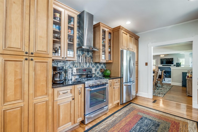 2220 Mistletoe Blvd, Fort Worth, TX 76110 - kitchen with wall chimney range hood, stainless steel appliances, decorative backsplash, light wood-style flooring, and glass insert cabinets
