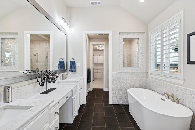 8229 Halifax, The Colony, TX 75056 - full bath with vaulted ceiling, a stall shower, a freestanding bath, double vanity, and tile patterned flooring