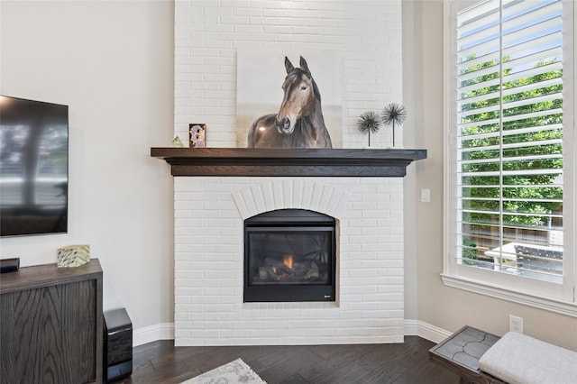 8229 Halifax, The Colony, TX 75056 - detailed view of baseboards, a brick fireplace, and wood finished floors