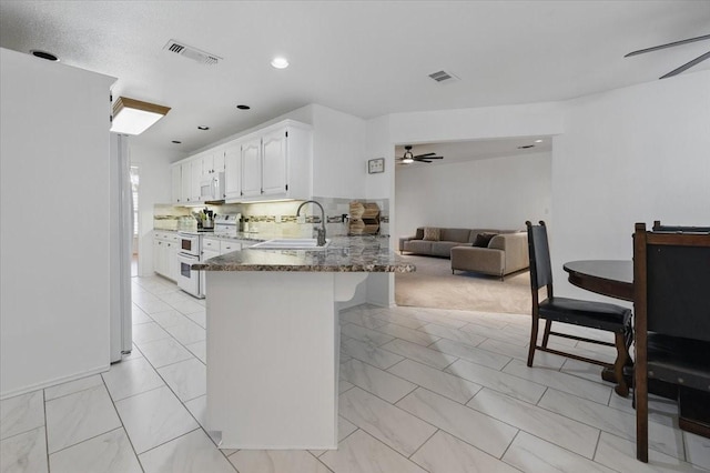 201 Wilson St, Whitesboro, TX 76273 - kitchen with white appliances, ceiling fan, a peninsula, light marble finish floors, and recessed lighting