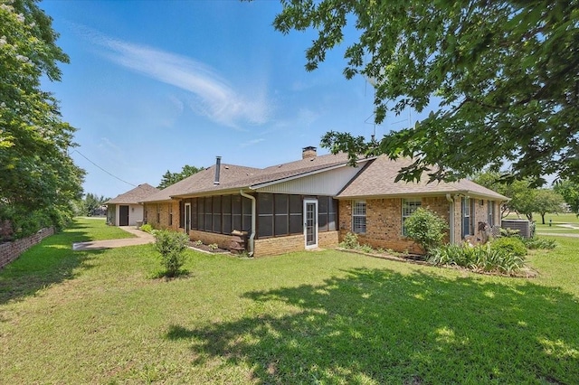 201 Wilson St, Whitesboro, TX 76273 - back of property featuring a chimney, a yard, a sunroom, and brick siding