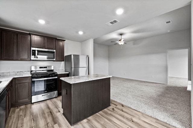 405 Watson Ct, Venus, TX 76084 - kitchen featuring stainless steel appliances, ceiling fan, dark brown cabinetry, a kitchen island, and open floor plan