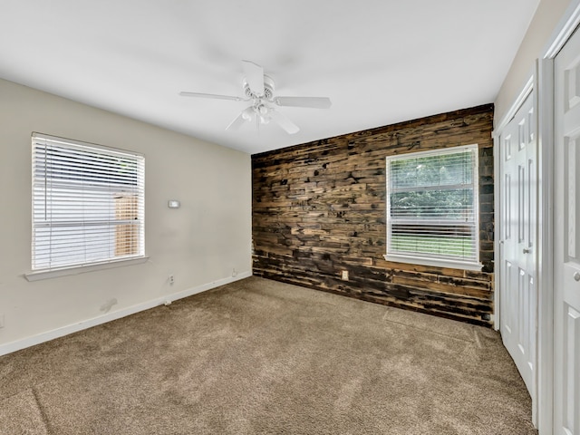 13439 Challaburton, Farmers Branch, TX 75234 - empty room featuring wood walls, carpet, healthy amount of natural light, ceiling fan, and baseboards