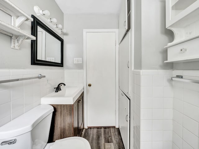 13439 Challaburton, Farmers Branch, TX 75234 - half bathroom featuring tile walls, toilet, a wainscoted wall, vanity, and wood finished floors