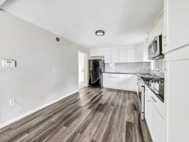 13439 Challaburton, Farmers Branch, TX 75234 - kitchen with stainless steel appliances, dark countertops, dark wood finished floors, tasteful backsplash, and a sink