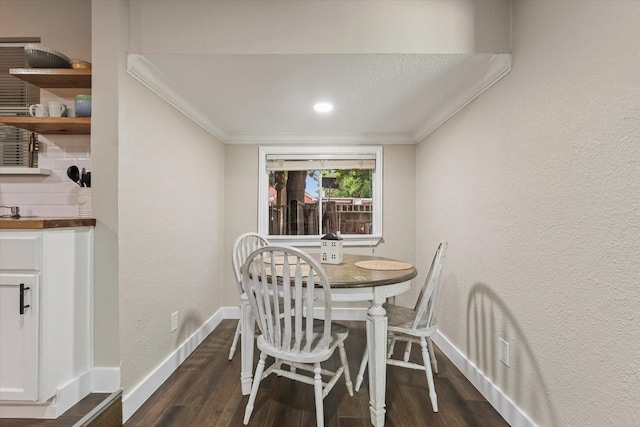 3200 Haltom Rd, Haltom City, TX 76117 - dining area with dark wood-style floors, a textured wall, baseboards, and ornamental molding