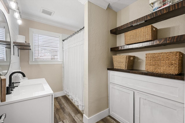 3200 Haltom Rd, Haltom City, TX 76117 - laundry room with a sink, ornamental molding, dark wood-style flooring, a textured wall, and baseboards