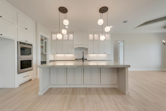 160 Maci Dr, Waxahachie, TX 75167 - kitchen featuring stainless steel double oven, tasteful backsplash, white cabinets, light wood-type flooring, and light stone counters