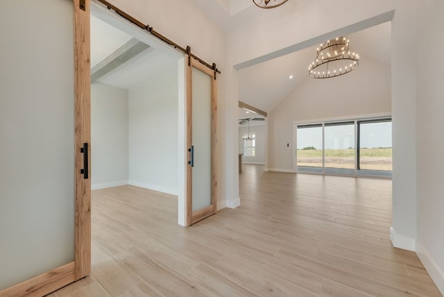 160 Maci Dr, Waxahachie, TX 75167 - hallway with a barn door, a chandelier, baseboards, light wood-style floors, and high vaulted ceiling