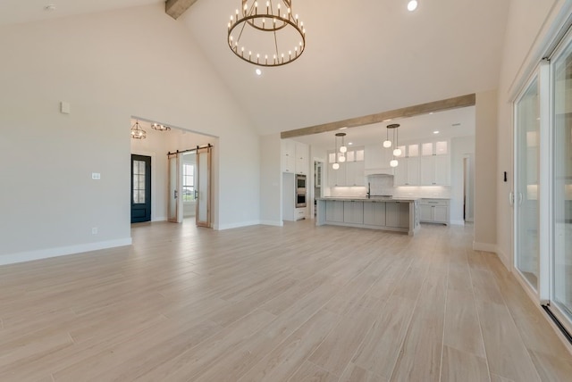 160 Maci Dr, Waxahachie, TX 75167 - unfurnished living room featuring high vaulted ceiling, a barn door, a chandelier, beam ceiling, and light wood-style floors