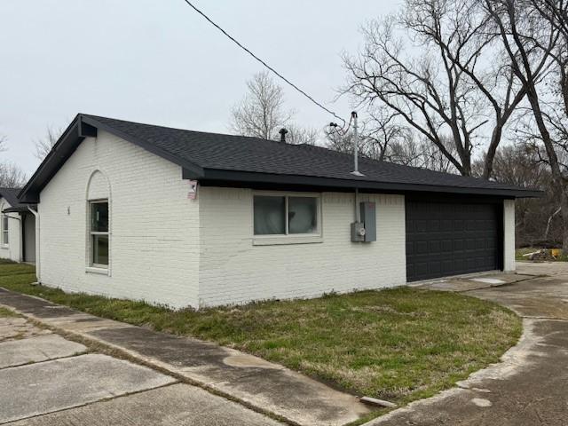 6300 Lumley Rd, Mesquite, TX 75181 - view of home's exterior with concrete driveway, an attached garage, brick siding, and roof with shingles