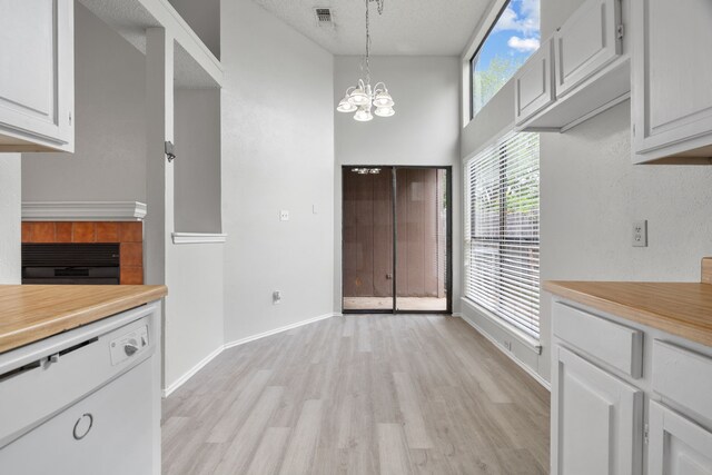2526 Butterfield Dr, Fort Worth, TX 76133 - unfurnished dining area featuring light wood-type flooring, a chandelier, baseboards, and a textured ceiling