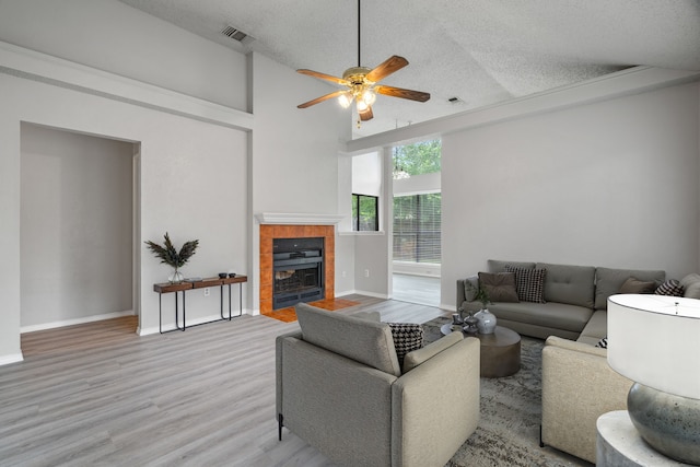 2526 Butterfield Dr, Fort Worth, TX 76133 - living room featuring a textured ceiling, ceiling fan, wood finished floors, a fireplace, and baseboards