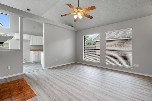 2526 Butterfield Dr, Fort Worth, TX 76133 - unfurnished living room with lofted ceiling, ceiling fan, a textured ceiling, light wood-type flooring, and baseboards