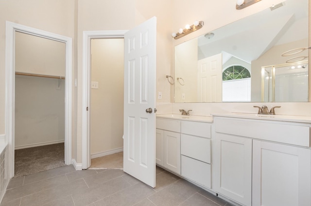 3010 Partridge Ln, Mckinney, TX 75072 - bathroom featuring double vanity, a walk in closet, tile patterned floors, lofted ceiling, and a shower with shower door