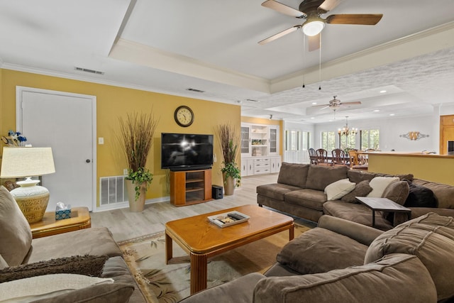 1407 S Alamo Rd, Rockwall, TX 75087 - living room with a tray ceiling, a ceiling fan, light wood-type flooring, crown molding, and a chandelier