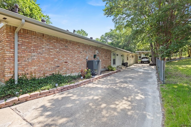 1407 S Alamo Rd, Rockwall, TX 75087 - view of home's exterior with brick siding, cooling unit, and driveway