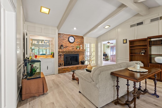 1407 S Alamo Rd, Rockwall, TX 75087 - living room with a decorative wall, light wood-style floors, and a brick fireplace